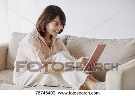 Young Japanese woman on sofa View Large Photo Image Stock Image - Young Japanese woman on sofa. Fotosearch