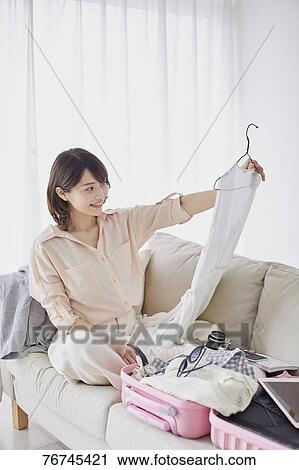 Stock Image - Young Japanese woman on sofa. Fotosearch