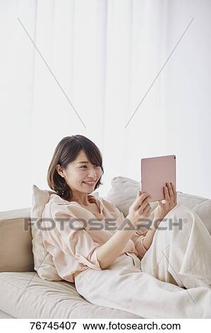 Young Japanese woman on sofa View Large Photo Image Stock Photo - Young Japanese woman on sofa. Fotosearch