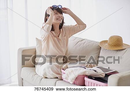Stock Photo - Young Japanese woman on sofa. Fotosearch
