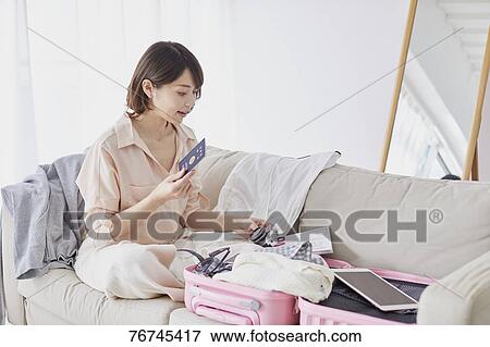 Stock Photo - Young Japanese woman on sofa. Fotosearch