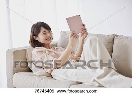 Young Japanese woman on sofa View Large Photo Image Stock Photography - Young Japanese woman on sofa. Fotosearch
