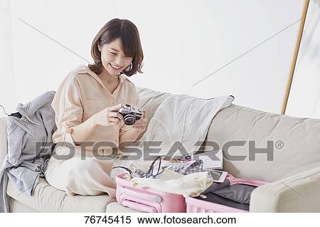 Stock Photography - Young Japanese woman on sofa. Fotosearch