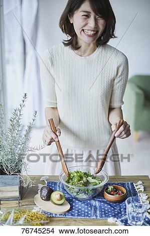 Picture - Young Japanese woman preparing salad. Fotosearch