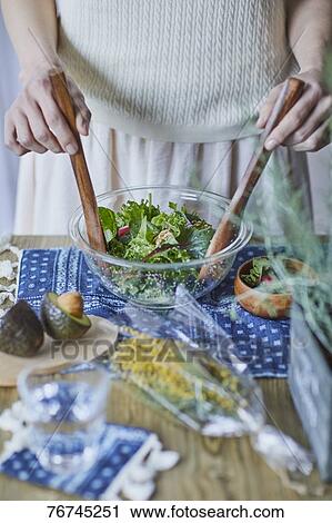 Stock Image - Young Japanese woman preparing salad. Fotosearch