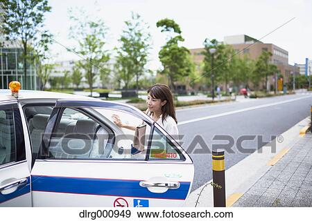 Young Japanese woman riding a taxi downtown Tokyo, Japan View Large Photo Image Stock Photo - Young Japanese woman riding a taxi downtown Tokyo, Japan. Fotosearch