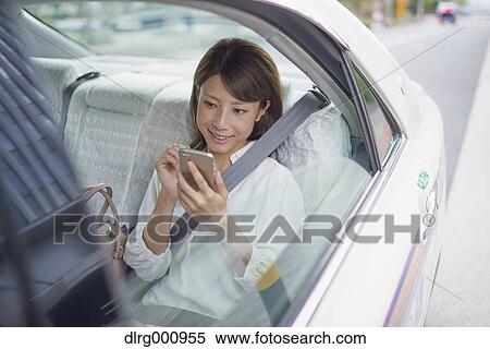 Young Japanese woman riding a taxi downtown Tokyo, Japan View Large Photo Image Stock Photography - Young Japanese woman riding a taxi downtown Tokyo, Japan. Fotosearch