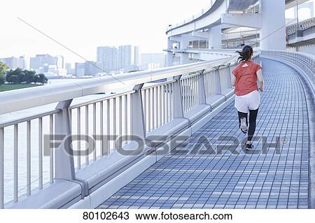 Stock Image - Young Japanese woman training downtown Tokyo. Fotosearch