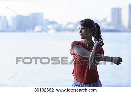 Stock Image - Young Japanese woman training downtown Tokyo. Fotosearch