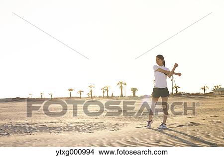 Picture - Young Japanese woman training on the beach. Fotosearch