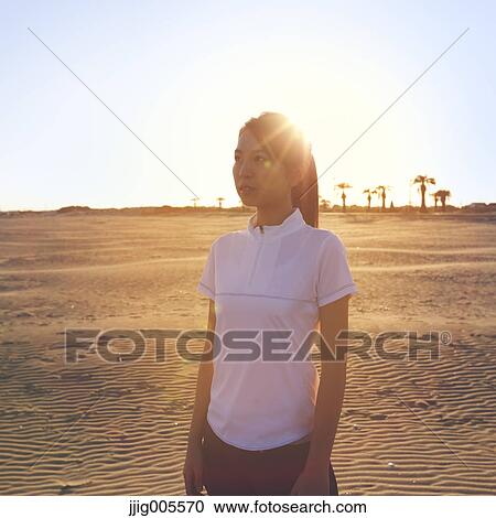 Stock Image - Young Japanese woman training on the beach. Fotosearch