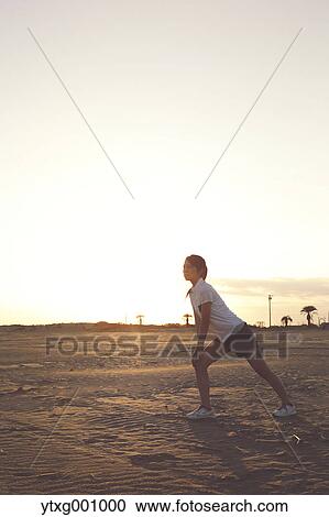 Stock Image - Young Japanese woman training on the beach. Fotosearch