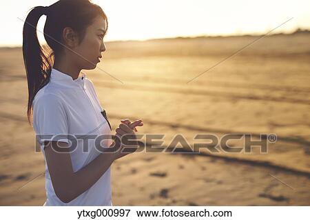 Young Japanese woman training on the beach View Large Photo Image Stock Photo - Young Japanese woman training on the beach. Fotosearch