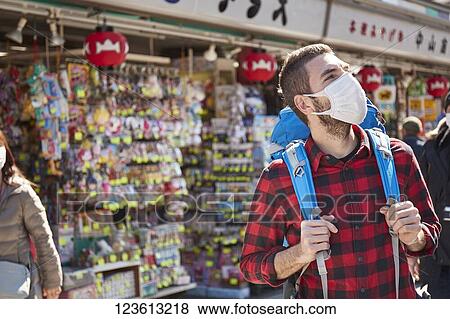 Caucasian tourist wearing a medical mask visiting Tokyo View Large Photo Image Stock Photo - Caucasian tourist wearing a medical mask visiting Tokyo. Fotosearch