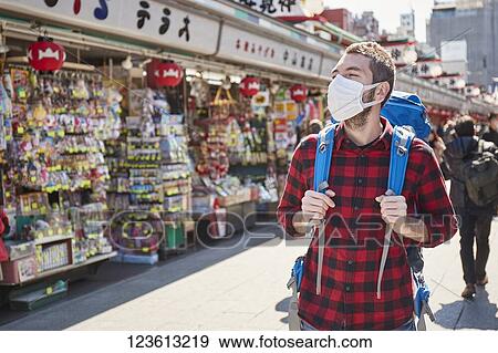Caucasian tourist wearing a medical mask visiting Tokyo View Large Photo Image Stock Photo - Caucasian tourist wearing a medical mask visiting Tokyo. Fotosearch