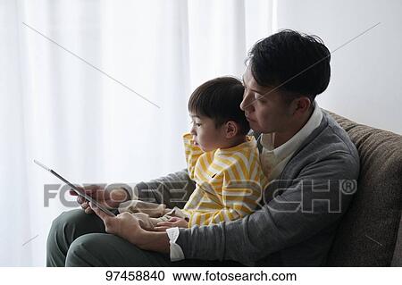 Stock Image - Father and son with tablet. Fotosearch
