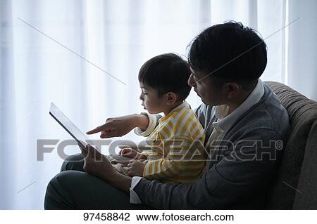 Stock Image - Father and son with tablet. Fotosearch