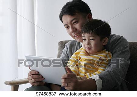 Stock Photo - Father and son with tablet. Fotosearch