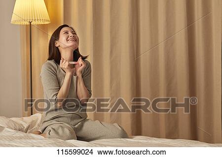 Happy Japanese woman with pregnancy test View Large Photo Image Picture - Happy Japanese woman with pregnancy test. Fotosearch