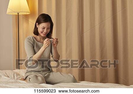 Happy Japanese woman with pregnancy test View Large Photo Image Stock Image - Happy Japanese woman with pregnancy test. Fotosearch