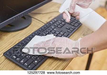 Japan man disinfecting keyboard with alcohol View Large Photo Image Stock Photo - Japan man disinfecting keyboard with alcohol. Fotosearch