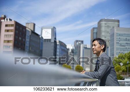 Stock Image - Japanese businessman downtown. Fotosearch