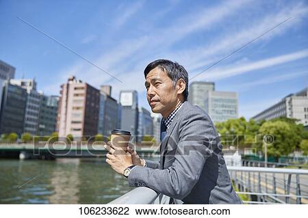 Stock Image - Japanese businessman downtown. Fotosearch