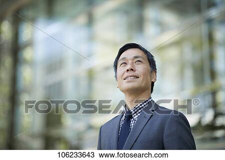 Stock Image - Japanese businessman downtown. Fotosearch