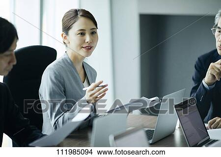 Picture - Japanese businesspeople having a meeting. Fotosearch