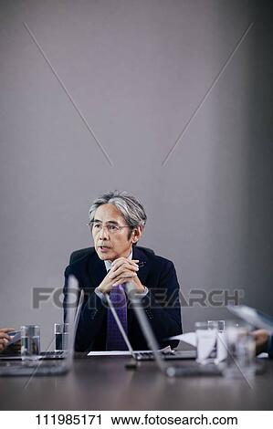 Stock Image - Japanese businesspeople having a meeting. Fotosearch