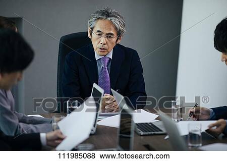 Stock Photo - Japanese businesspeople having a meeting. Fotosearch