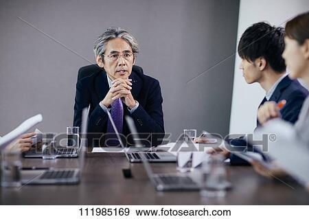 Stock Photo - Japanese businesspeople having a meeting. Fotosearch