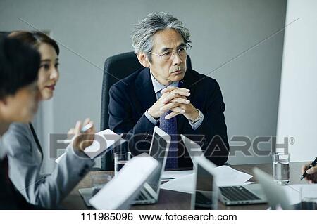 Japanese businesspeople having a meeting View Large Photo Image Stock Photograph - Japanese businesspeople having a meeting. Fotosearch