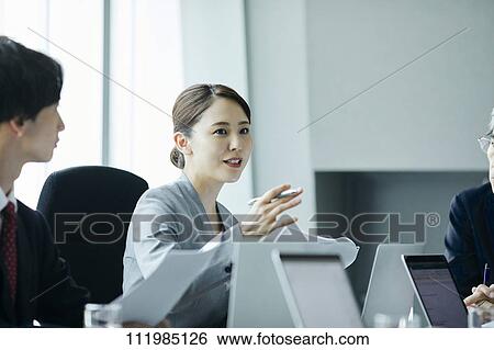 Stock Photograph - Japanese businesspeople having a meeting. Fotosearch
