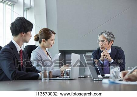 Stock Image - Japanese businesspeople in a meeting. Fotosearch