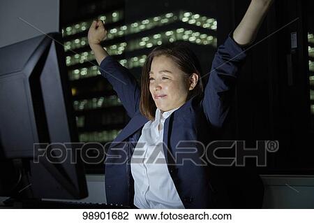 Stock Image - Japanese businesswoman working late at night. Fotosearch