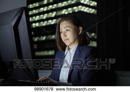 Stock Photo - Japanese businesswoman working late at night. Fotosearch