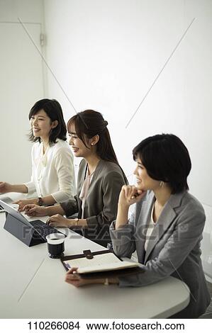 Picture - Japanese businesswomen in the office. Fotosearch