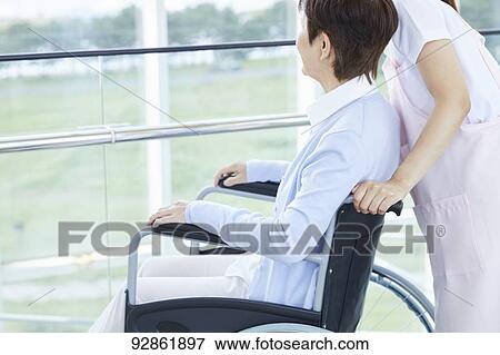Stock Photo - Japanese caretaker helping senior patient. Fotosearch