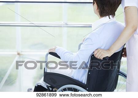 Stock Photo - Japanese caretaker helping senior patient. Fotosearch
