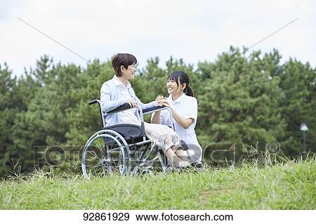 Stock Photo - Japanese caretaker helping senior patient. Fotosearch