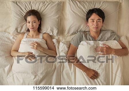 Picture - Japanese couple in bed. Fotosearch