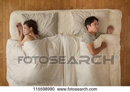 Stock Image - Japanese couple in bed. Fotosearch