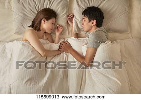 Stock Image - Japanese couple in bed. Fotosearch