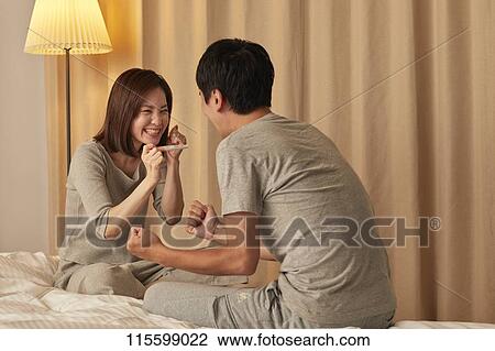 Stock Image - Japanese couple in bed. Fotosearch