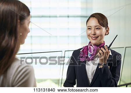 Japanese Flight Attendant helping customer View Large Photo Image Stock Image - Japanese Flight Attendant helping customer. Fotosearch