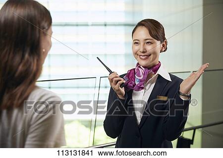 Japanese Flight Attendant helping customer View Large Photo Image Stock Image - Japanese Flight Attendant helping customer. Fotosearch