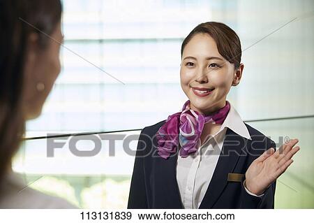 Stock Photo - Japanese Flight Attendant helping customer. Fotosearch