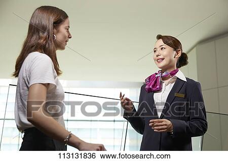 Japanese Flight Attendant helping customer View Large Photo Image Stock Photograph - Japanese Flight Attendant helping customer. Fotosearch