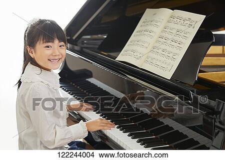 Picture - Japanese kid practicing piano. Fotosearch